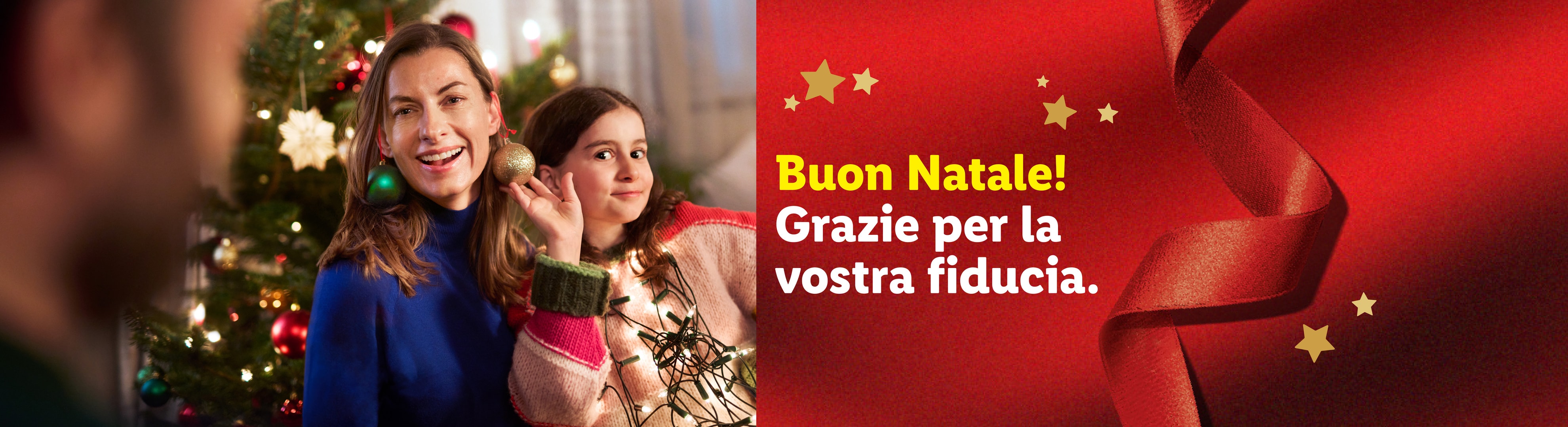 Due donne sorridenti con decorazioni natalizie, testo: Buon Natale! Grazie per la vostra fiducia.