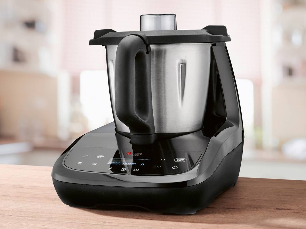 Schwarze und silberne Multifunktions-Küchenmaschine auf einem Holztisch.