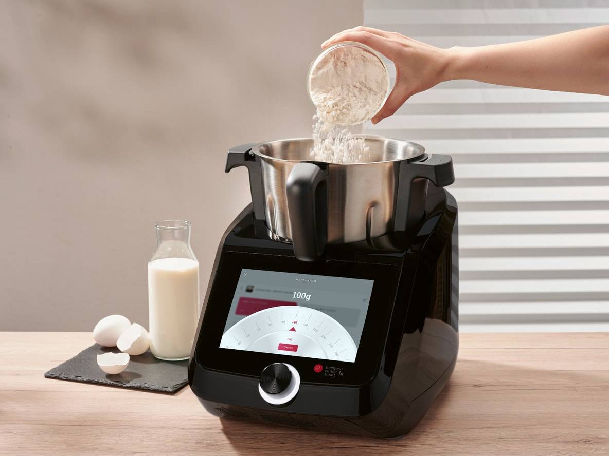 Multifunktions-Küchenmaschine mit Touchscreen, Mehl wird hinzugefügt, mit Milch und Eiern.