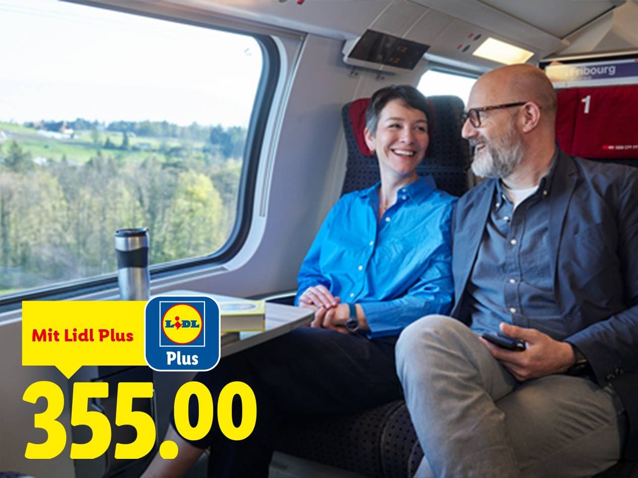 Ein lächelndes Paar in einem Zug, mit einem Angebot von 355.00 über die Treue-App.