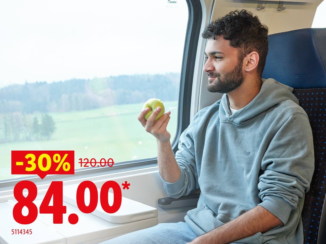 Mann im Zug mit Kapuzenpullover, hält einen grünen Apfel, mit 30% Rabatt auf 84,00.