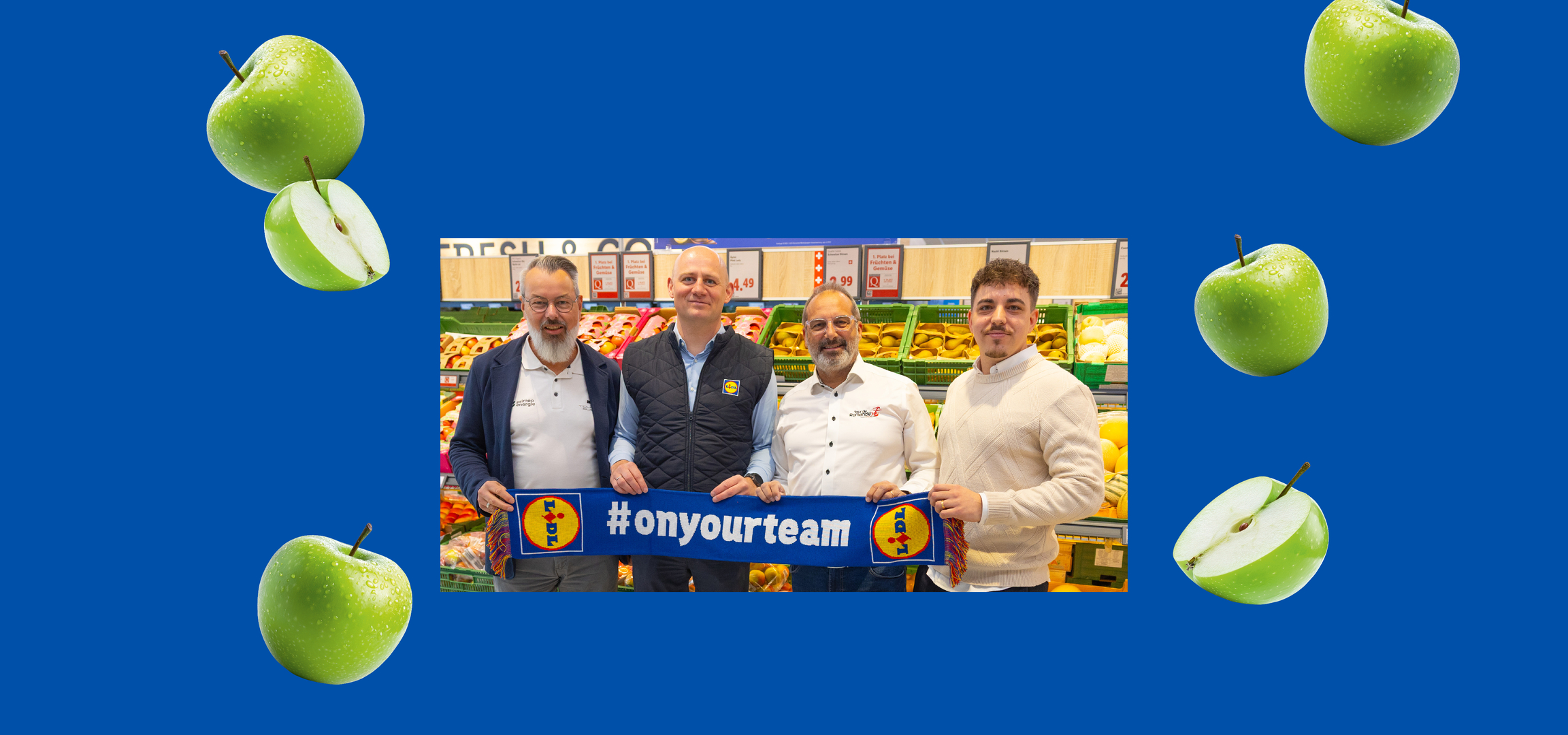 Hommes souriants dans un supermarché, avec des pommes vertes et une bannière bleue #onyourteam.