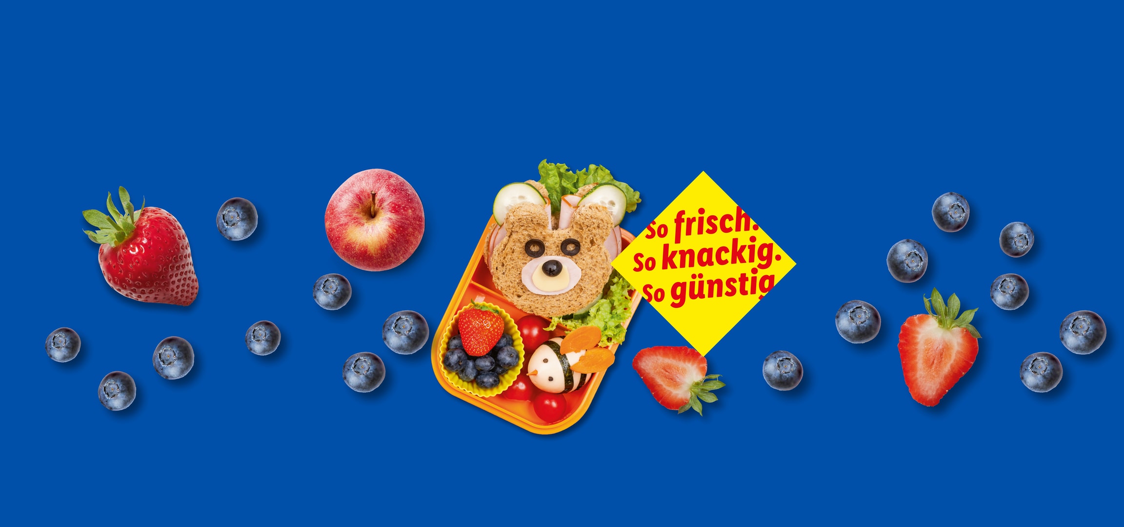 Divertente pranzo per bambini con un panino a forma di orso, frutta e bacche.