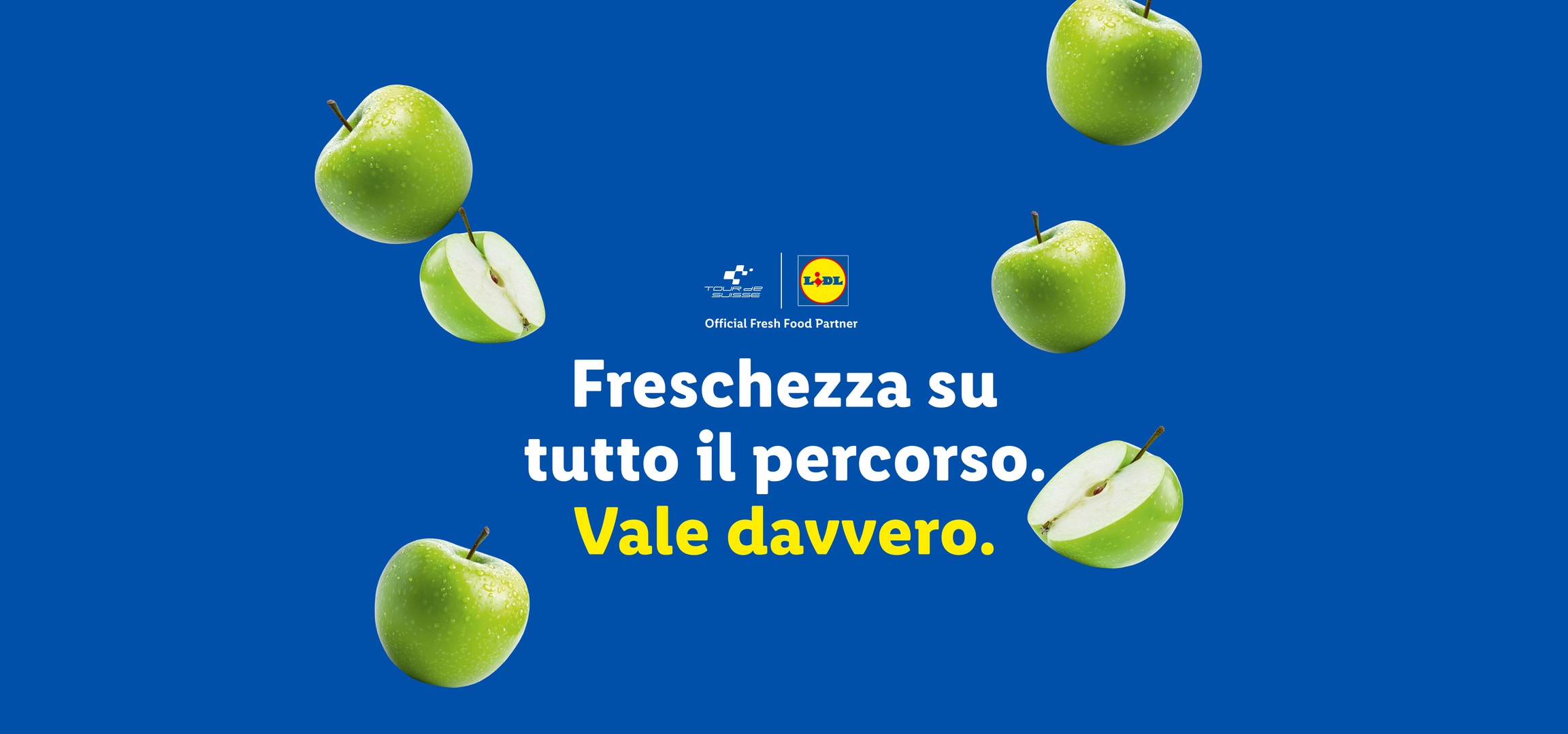 Mele verdi fresche su sfondo blu con testo: 'Freschezza su tutto il percorso. Vale davvero.'