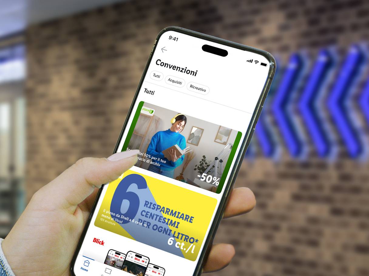 Una mano tiene uno smartphone che mostra un'app con sconti su carburante e spazio di archiviazione.