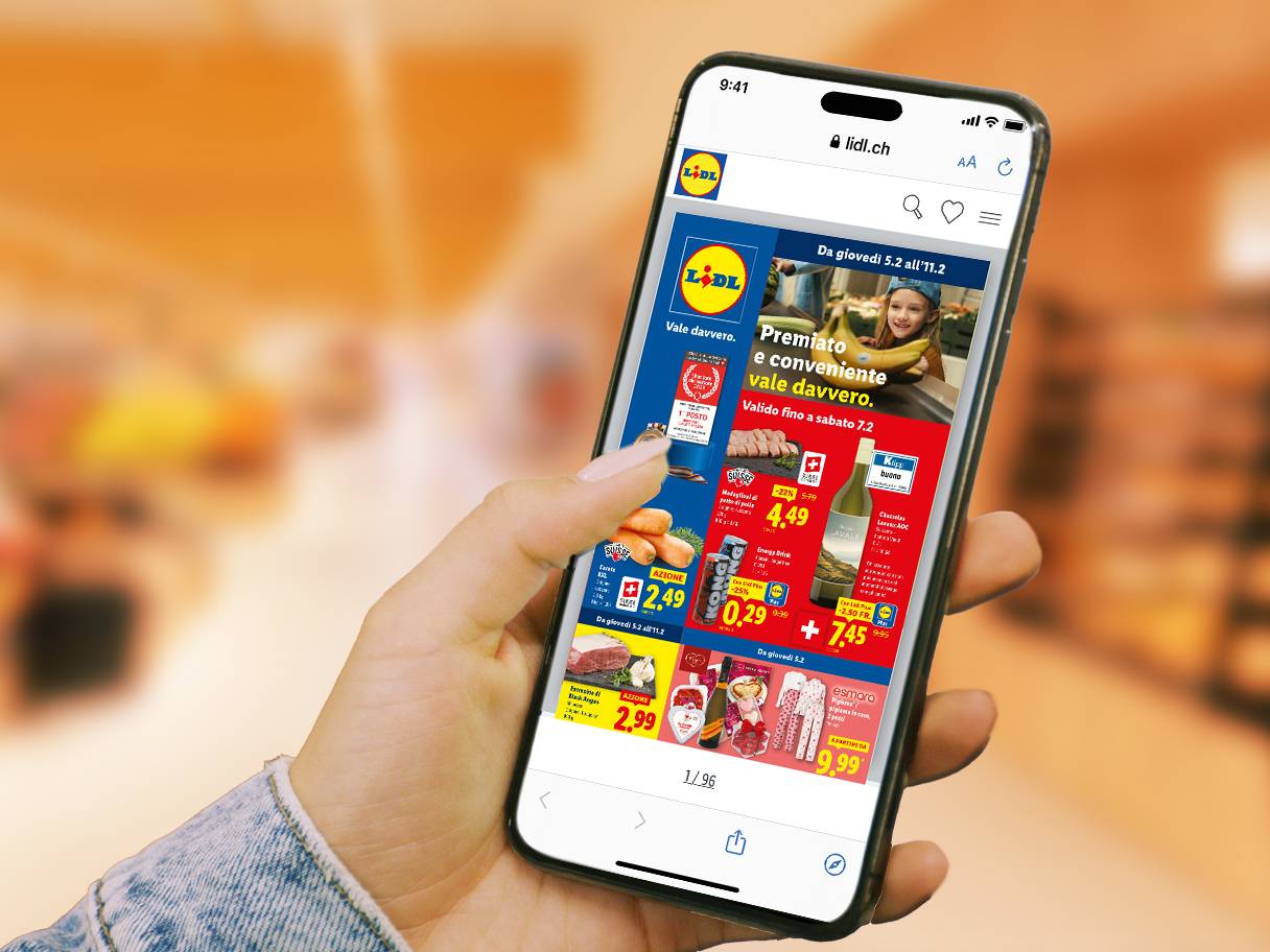 Mano che tiene uno smartphone con volantino digitale che mostra alimentari, vino e abbigliamento scontati.