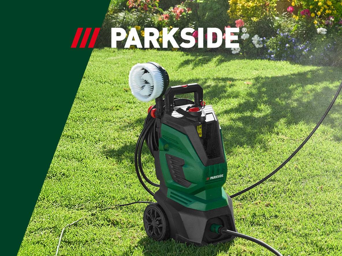 Nettoyeur haute pression vert avec brosse rotative sur une pelouse ensoleillée.