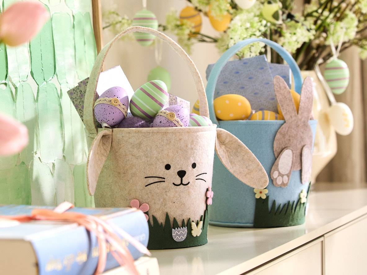 Zwei Filz-Osterkörbe, einer beige in Hasenform, der andere blau mit einem Hasen.