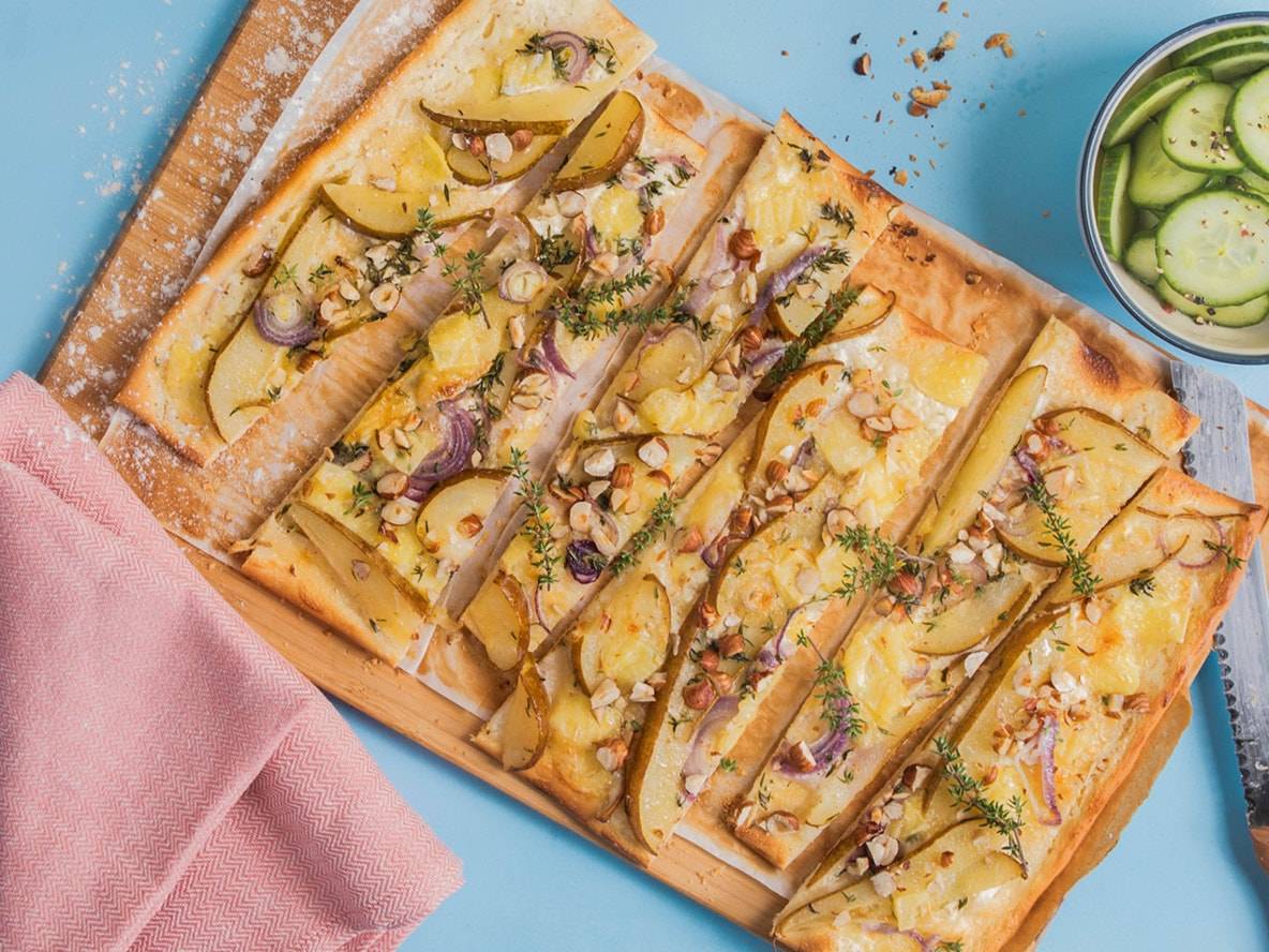Focaccia mit Birnen, roten Zwiebeln, Haselnüssen und Thymian, dazu eingelegte Gurken.