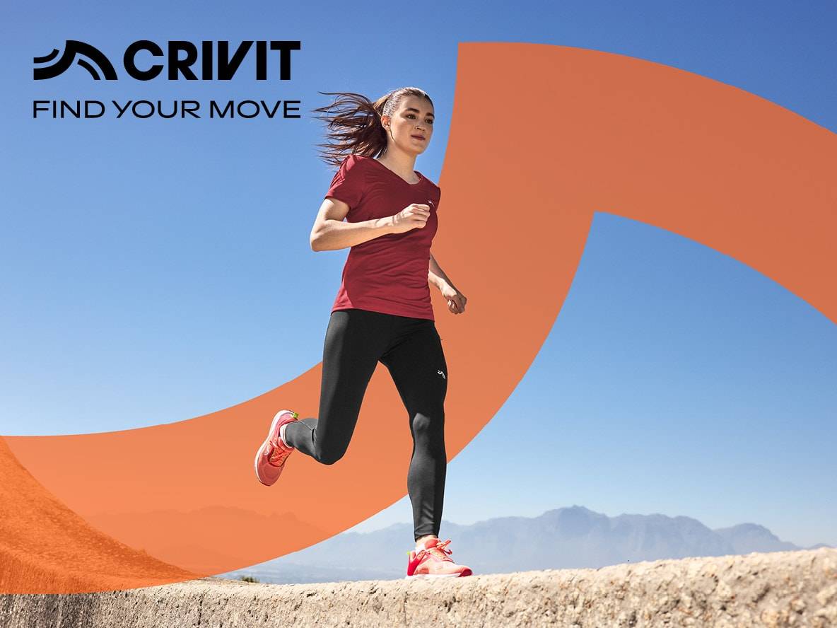 Frau in Sportkleidung läuft, blauer Himmel und Berge im Hintergrund.