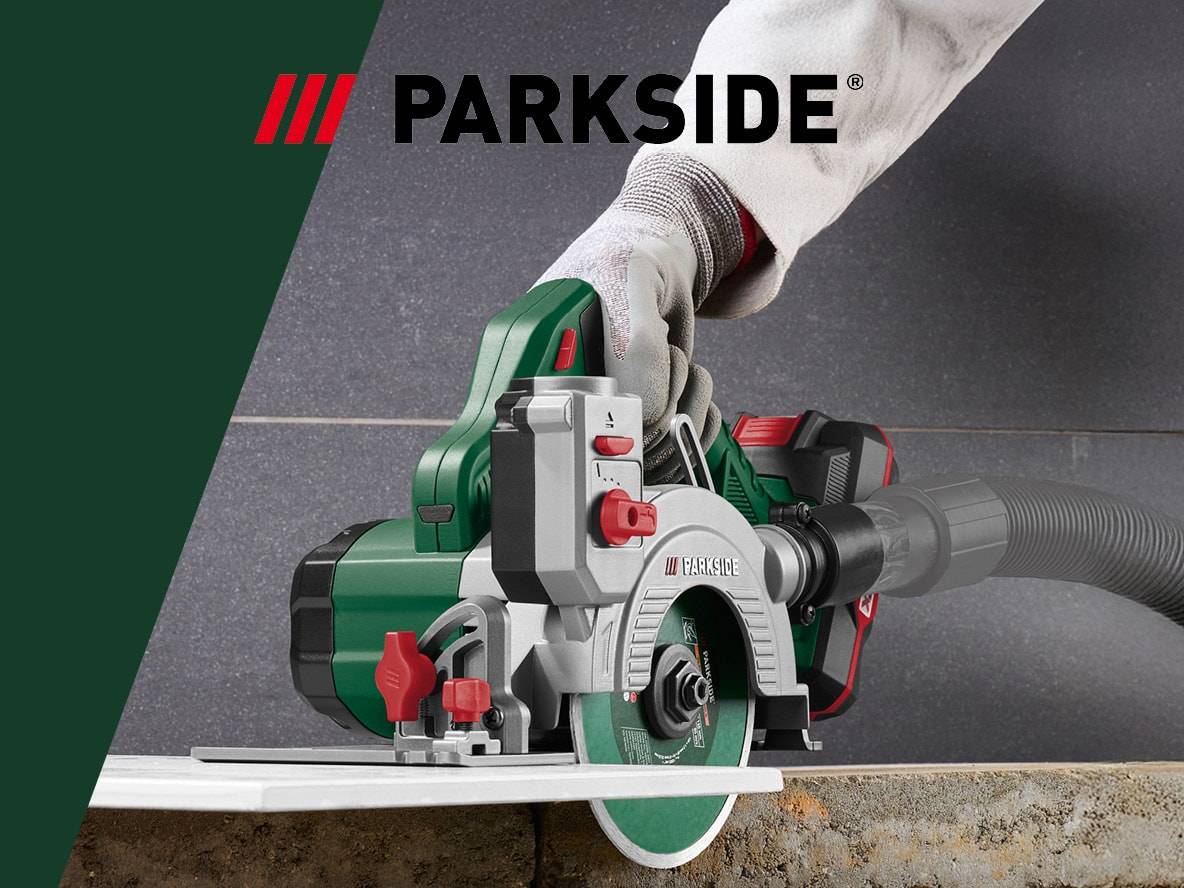 Akku-Kreissäge mit Absaugung, schneidet Fliesen mit einer behandschuhten Hand.