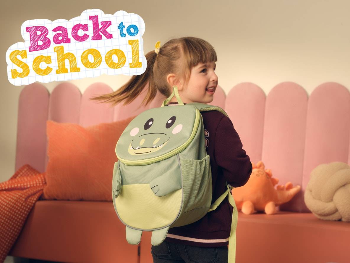 Une petite fille avec un sac à dos crocodile, prête pour la rentrée scolaire.
