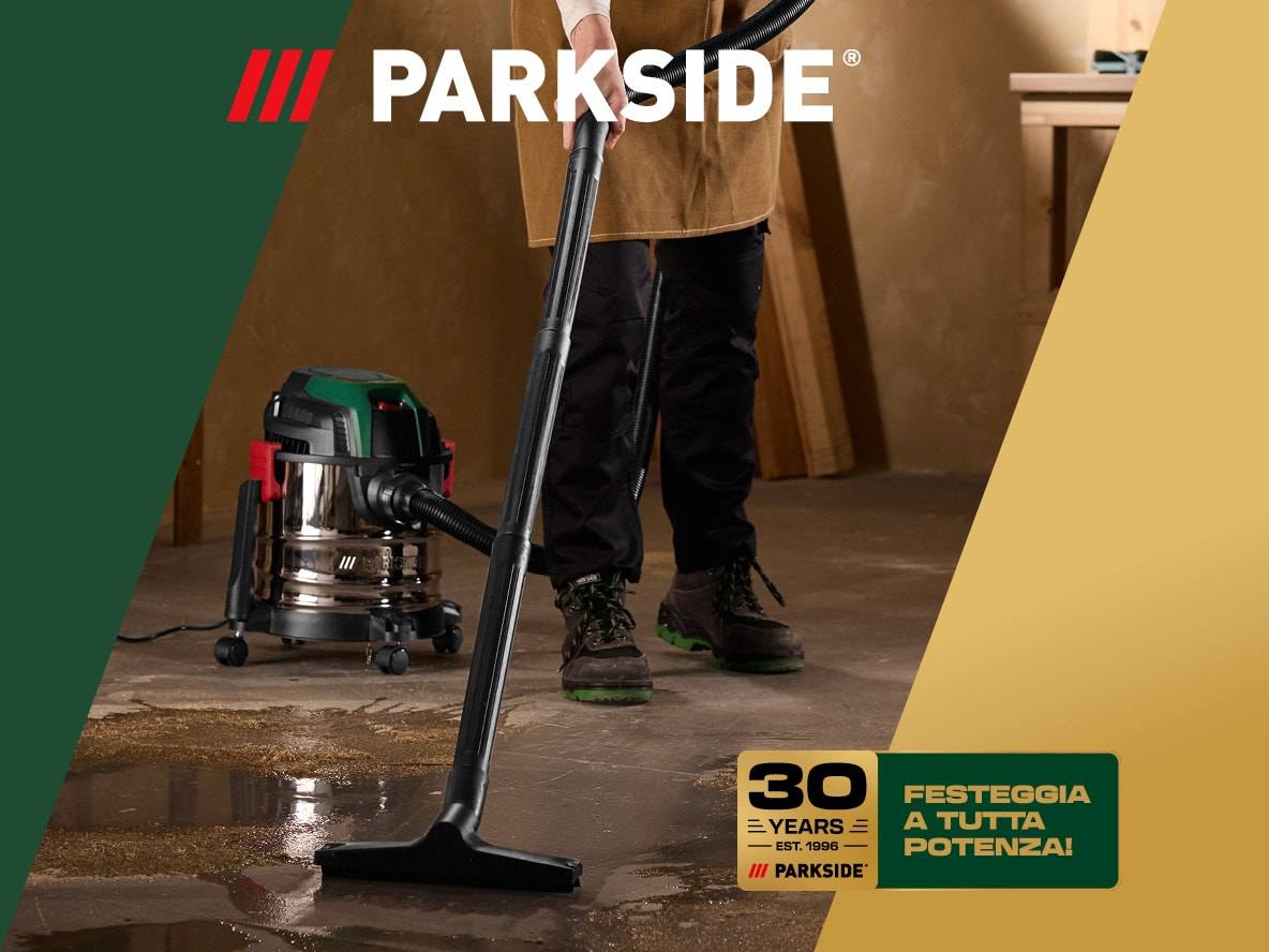 Aspirapolvere industriale in azione, con testo '30 ANNI - FESTEGGIA A TUTTA POTENZA!'