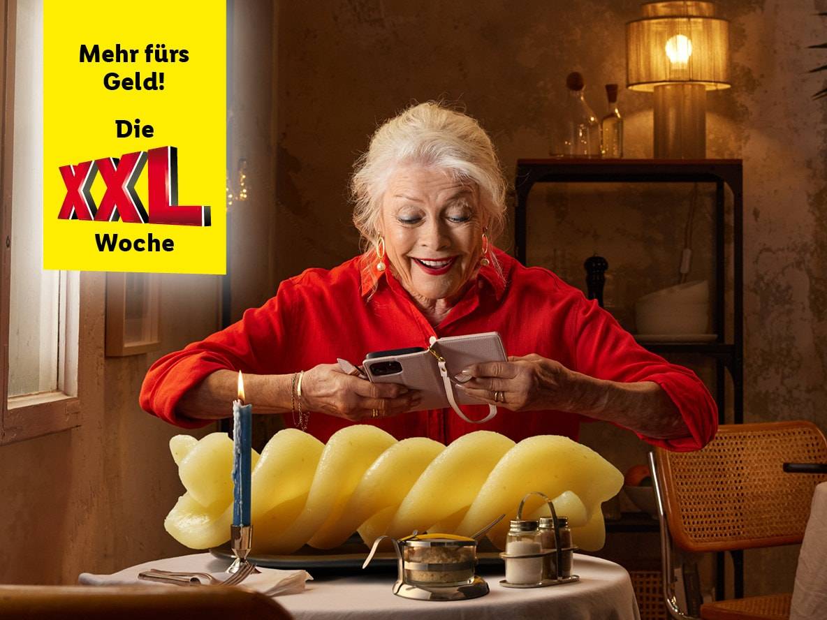 Ältere Frau nutzt ihr Handy während der XXL Woche Aktion.