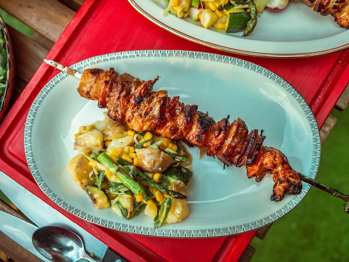 Spiedini di pollo grigliati con contorno di verdure.