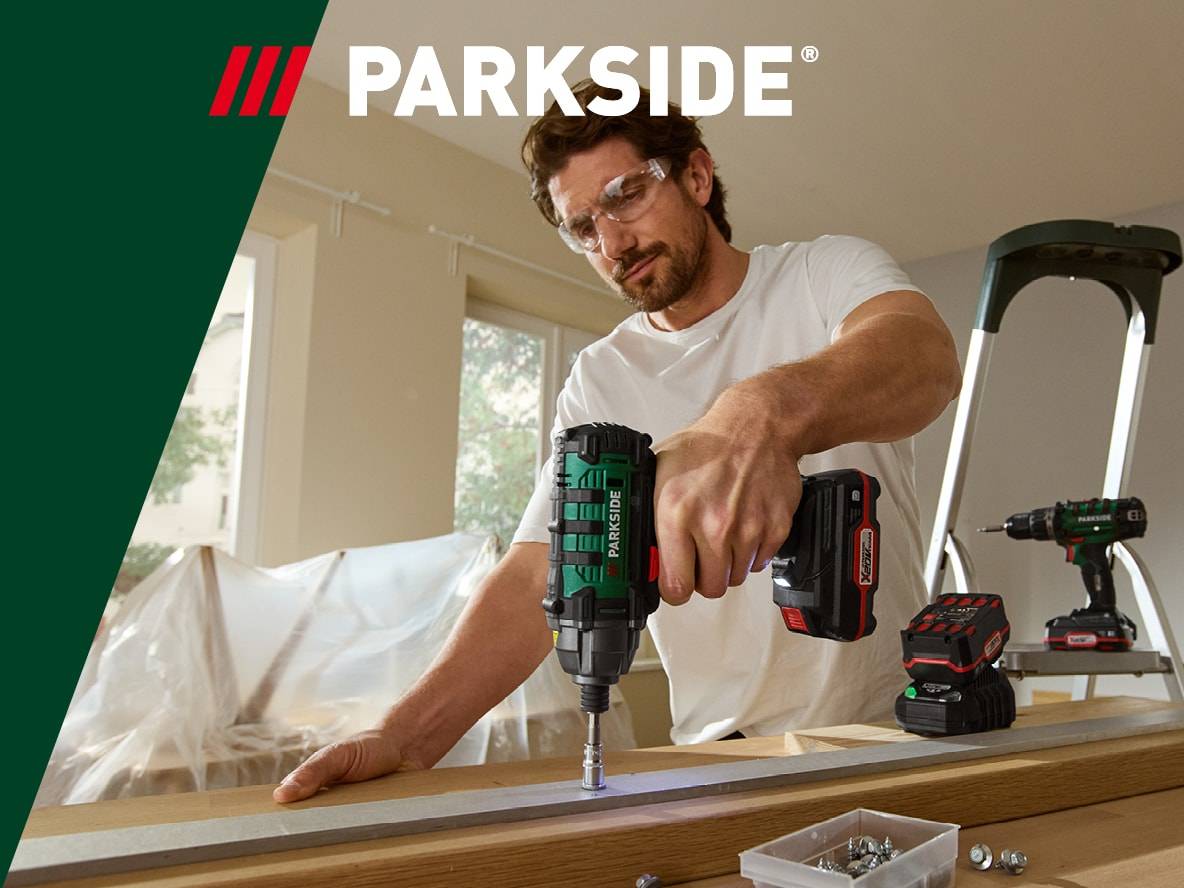 Ein Mann benutzt einen Parkside Akkuschrauber, um eine Schraube in ein Holzstück zu drehen.