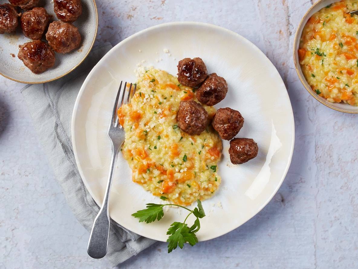 Fleischbällchen mit cremigem Risotto, garniert mit Petersilie und Parmesan