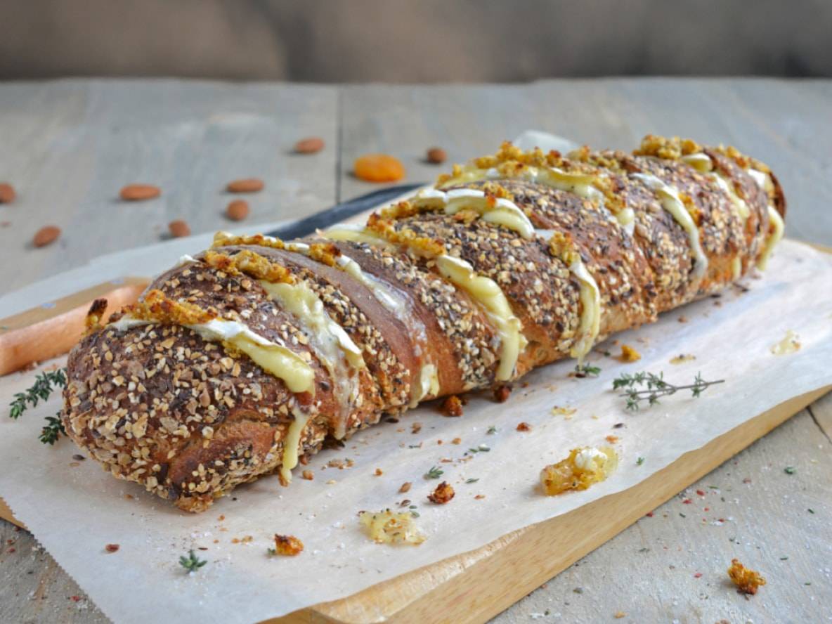 Nuss-Käse-Brot mit Kräutern auf einem Holzschneidebrett