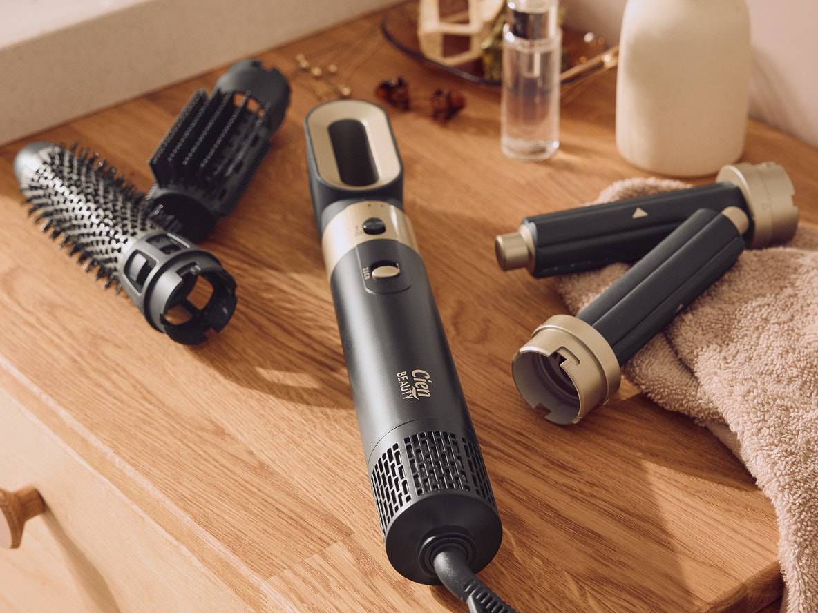 Brosse soufflante Cien Beauty avec accessoires interchangeables sur une surface en bois.