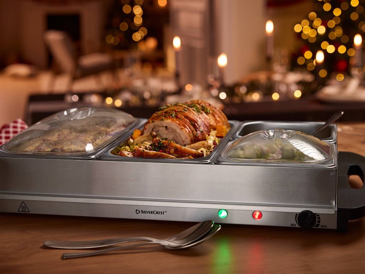 SilverCrest Speisenwärmer mit Braten und Gemüse auf einem weihnachtlich gedeckten Tisch.