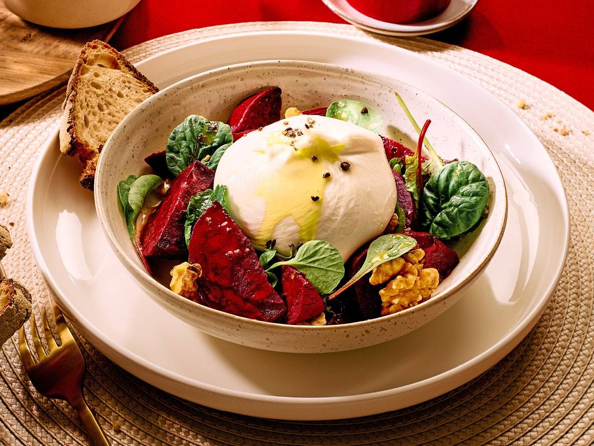 Salat mit Burrata, Roter Bete, Walnüssen und Spinat, mit Olivenöl beträufelt, dazu Brot.