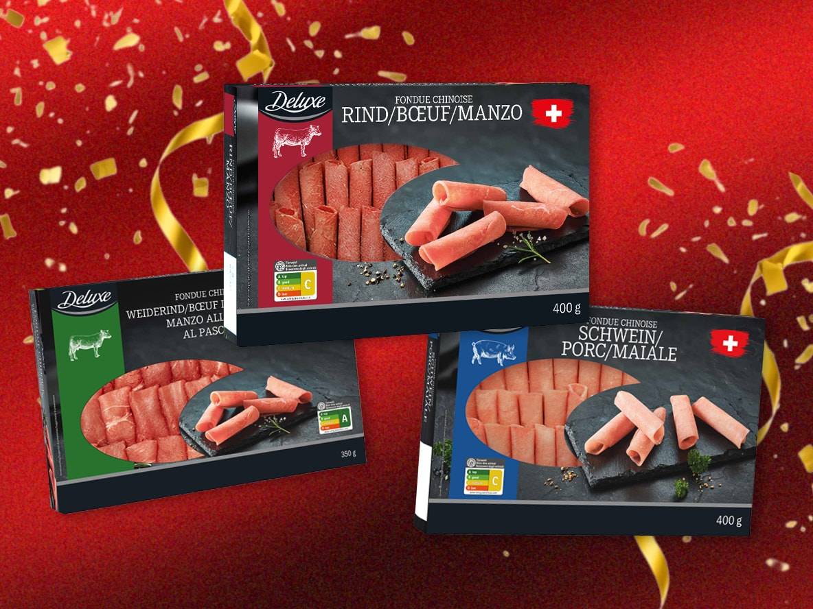 Deluxe Fondue Chinoise Rind- und Schweinefleischpackungen auf rotem Hintergrund mit Konfetti.