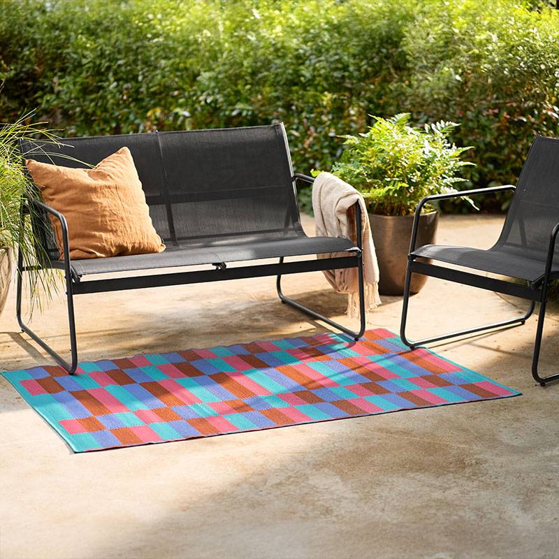 Meubles de jardin et tapis géométrique.