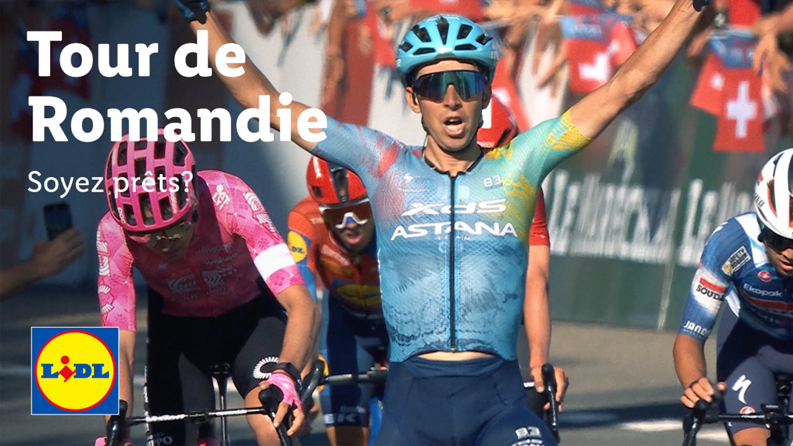 Cyclistes en course avec le texte 'Tour de Romandie' et 'Soyez prêts ?' en surimpression.