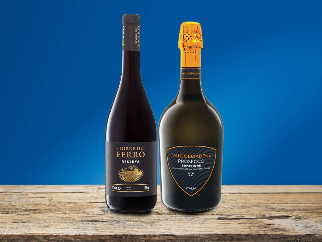 Une bouteille de vin rouge « Torre de Ferro Reserva Dão » et une bouteille de Prosecco « Valdobbiadene Superiore Extra Dry » sur une table en bois.