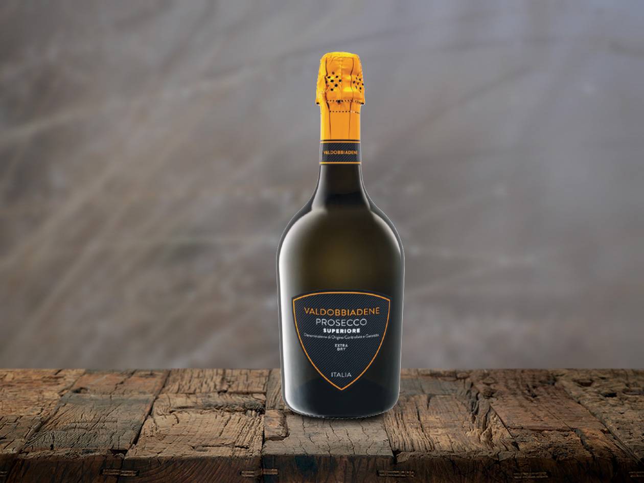 Flasche Valdobbiadene Prosecco Superiore Extra Dry auf einem Holztisch.