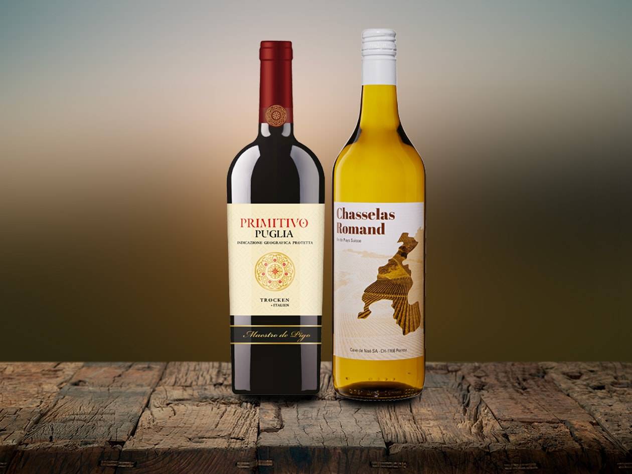 Zwei Weinflaschen, eine rote und eine weiße, auf einer rustikalen Holzoberfläche.