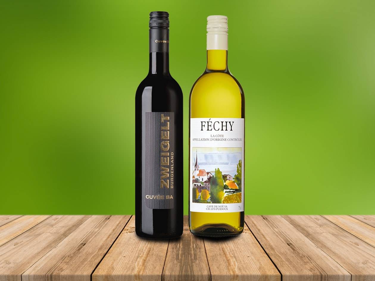 Zwei Weinflaschen, eine rote und eine weiße, auf einem Holztisch.