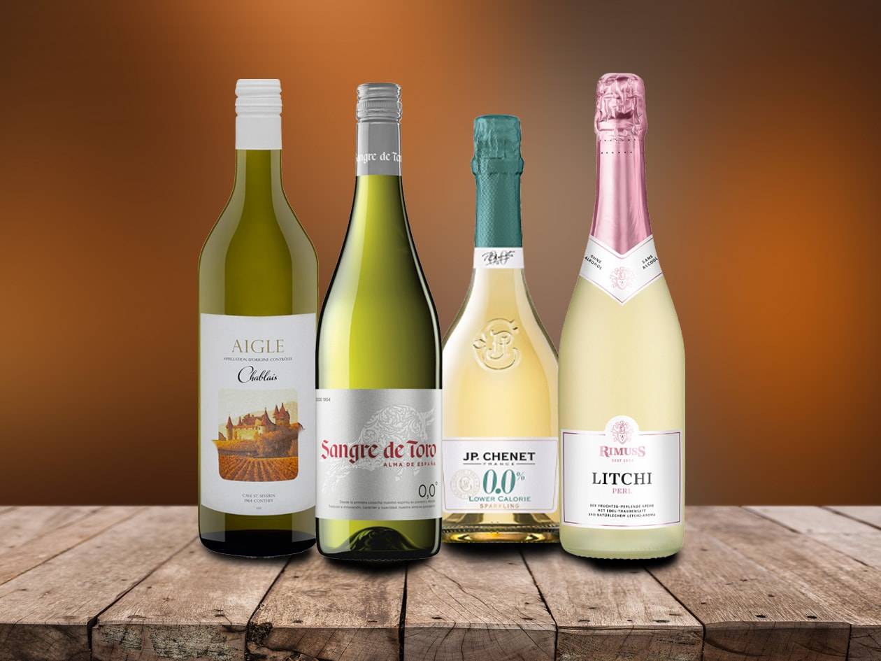 Vier Flaschen Weißwein und Sekt, davon zwei alkoholfrei, auf einem Holztisch.