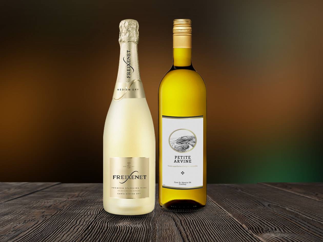 Deux bouteilles de vin, un mousseux et un vin blanc, sur une table en bois.