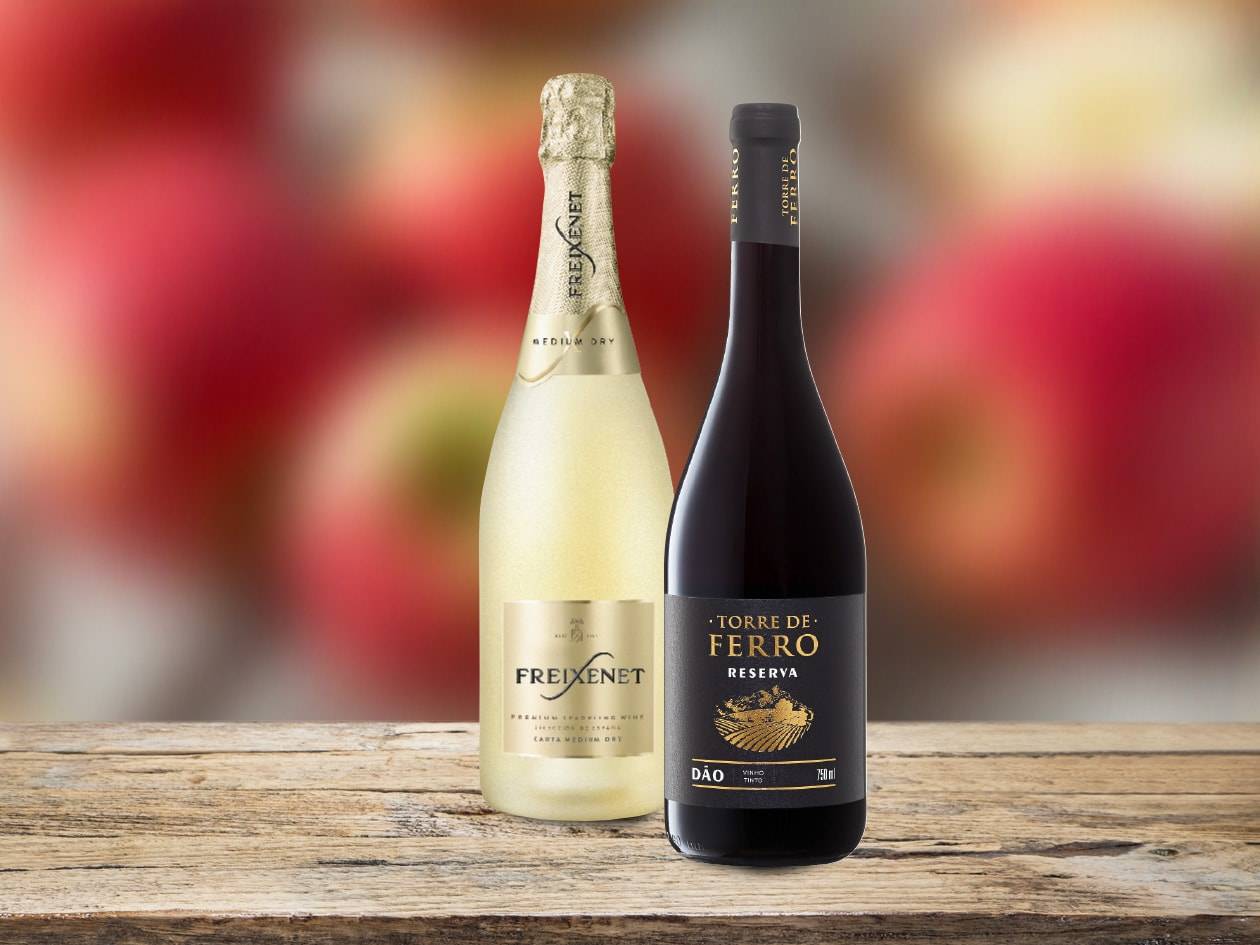 Una bottiglia di Freixenet e una bottiglia di Torre de Ferro Reserva su un tavolo di legno.