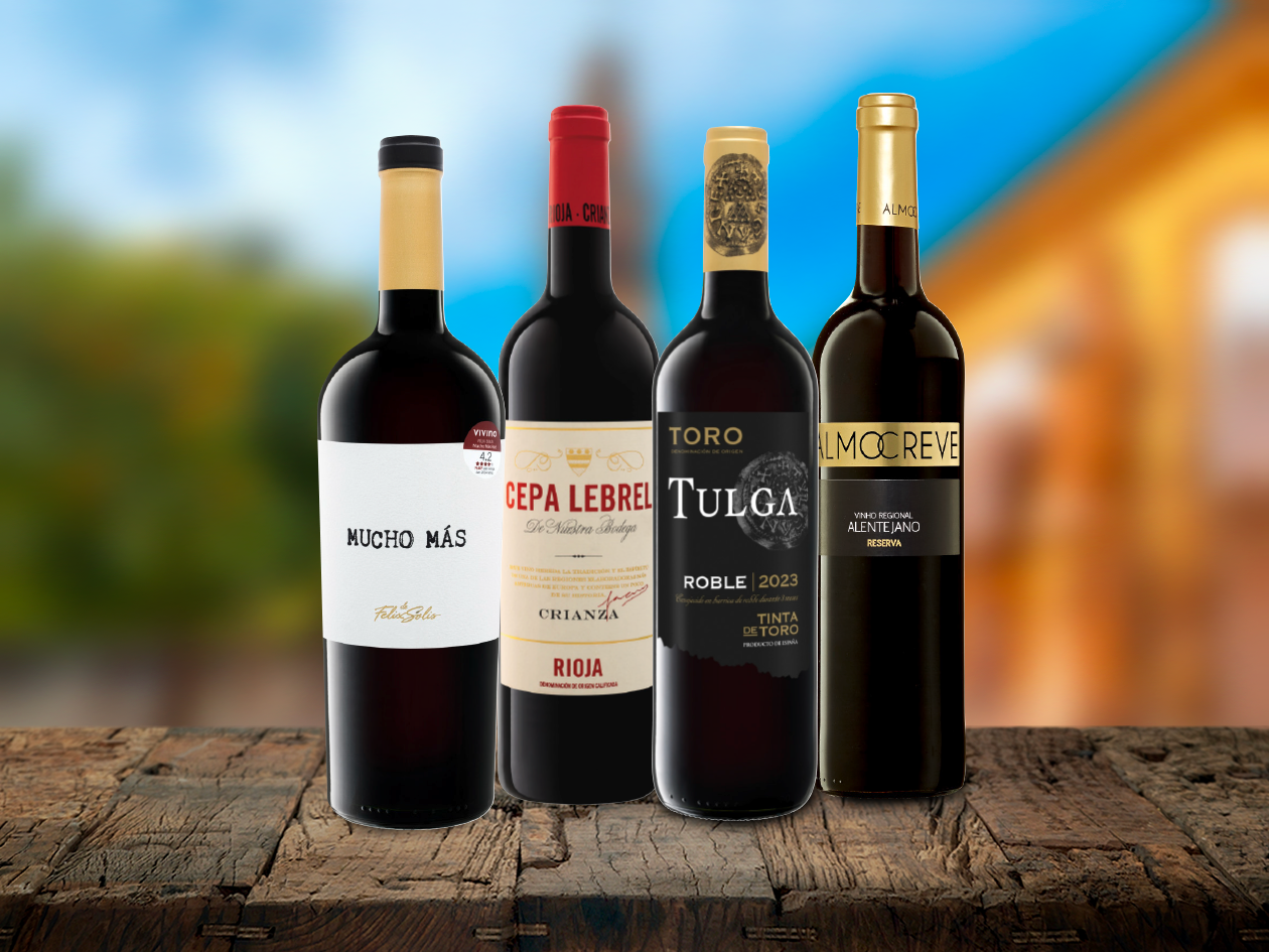 Quatre vins rouges espagnols : Mucho Más, Cepa Lebrel, Tulga et Almocreve sont disposés sur une table en bois.